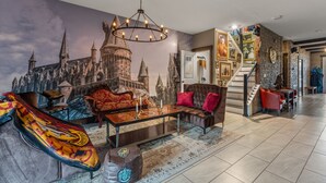 Un soggiorno con un affresco raffigurante un castello, un lampadario, un divano e un tavolino da caffè.