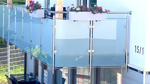 A modern building with a balcony, a staircase, and a window with the number 15/1. - Schönes helles Studio-Appartement mit großem Balkon (Engelsbrand)