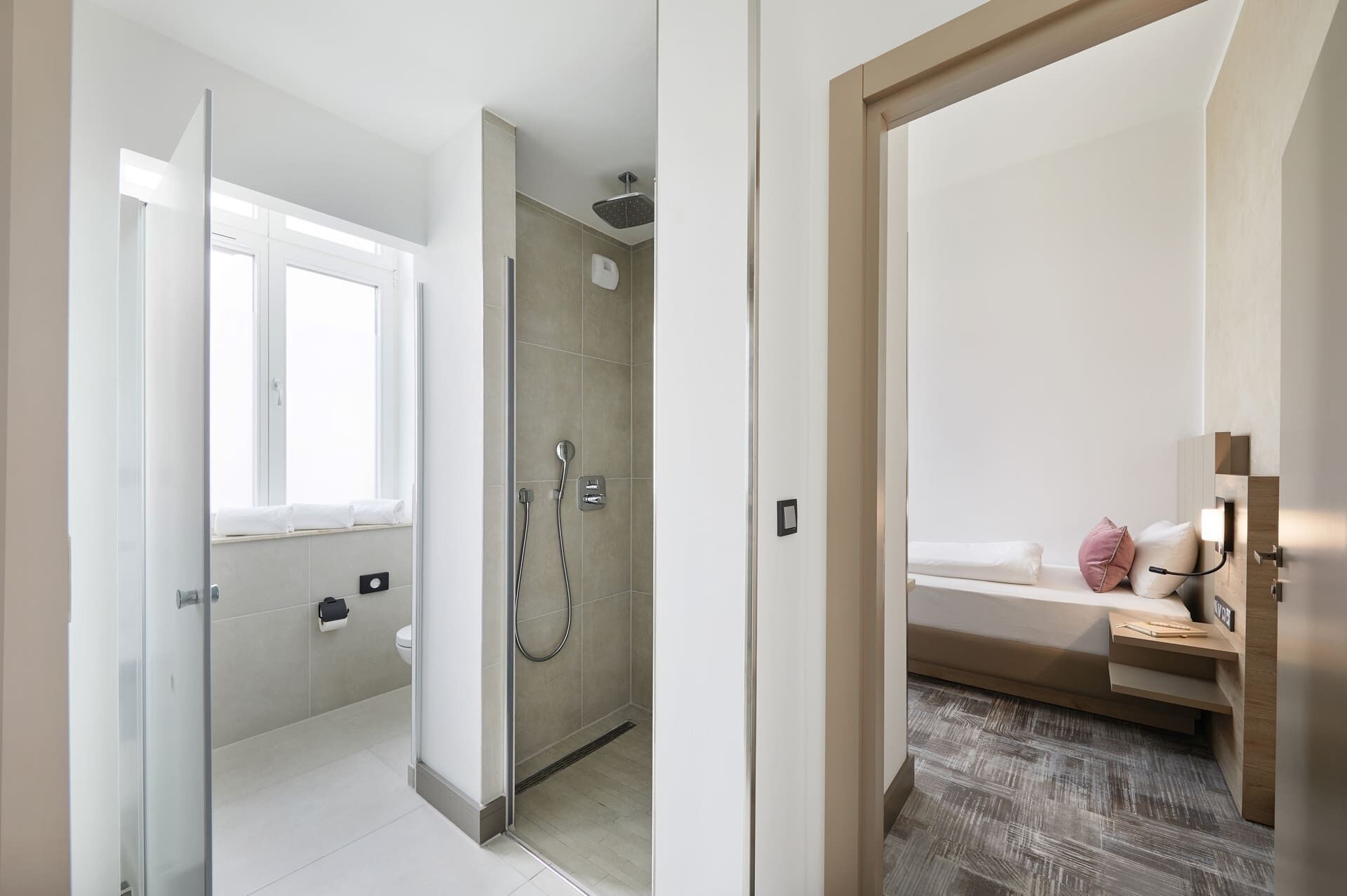 A modern bathroom with a glass shower enclosure, a toilet, and a sink.
