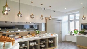 Cocina moderna con un sistema tipo buffet, que incluye una barra con alimentos y una variedad de electrodomésticos.