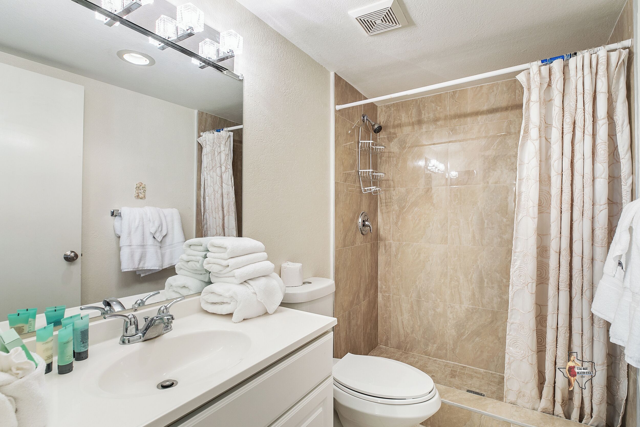 Ein modernes Badezimmer mit Waschbecken, Spiegel und Dusche.