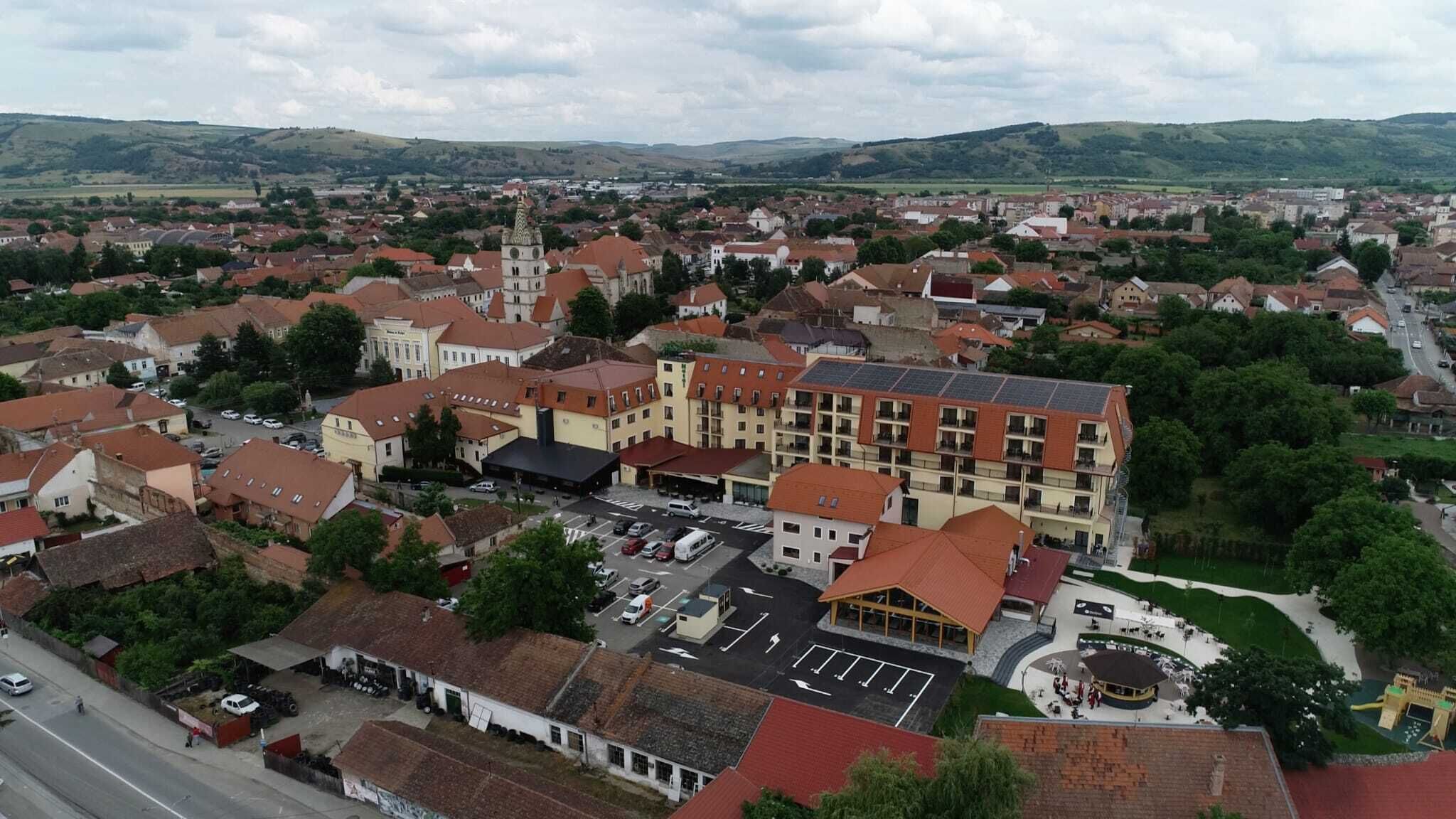 A town with a prominent building featuring a central courtyard, surrounded by residential and commercial buildings.