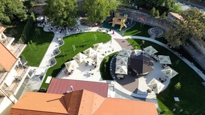 An outdoor area with a playground, seating areas, and umbrellas.