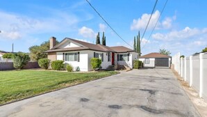 A single-story house with a front garage, a well-maintained lawn, and a clear sky. - Luxury Stay Near Poppy Fields, Aerospace & Antelope Valley (Lancaster)