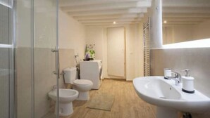 A modern bathroom with a glass shower enclosure, a white sink with a soap dispenser, and two toilets. - Historic Palazzo, Central Location, 3 bedrooms retreat. Best Florence Booking (Firenze)