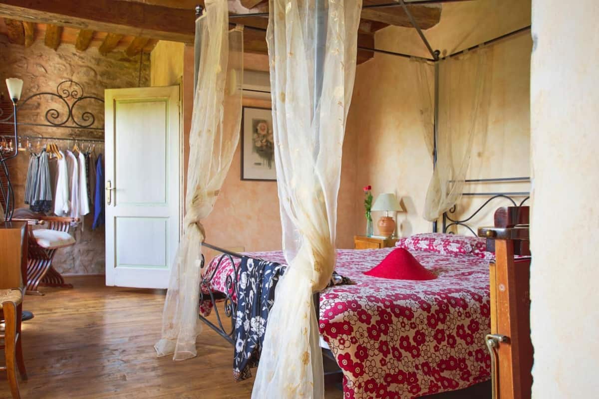 Un dormitorio con cama, una silla, un armario y una puerta.