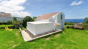 A white house with a tiled roof, a small porch, and a view of the sea. - Candelaria House (Candelária)