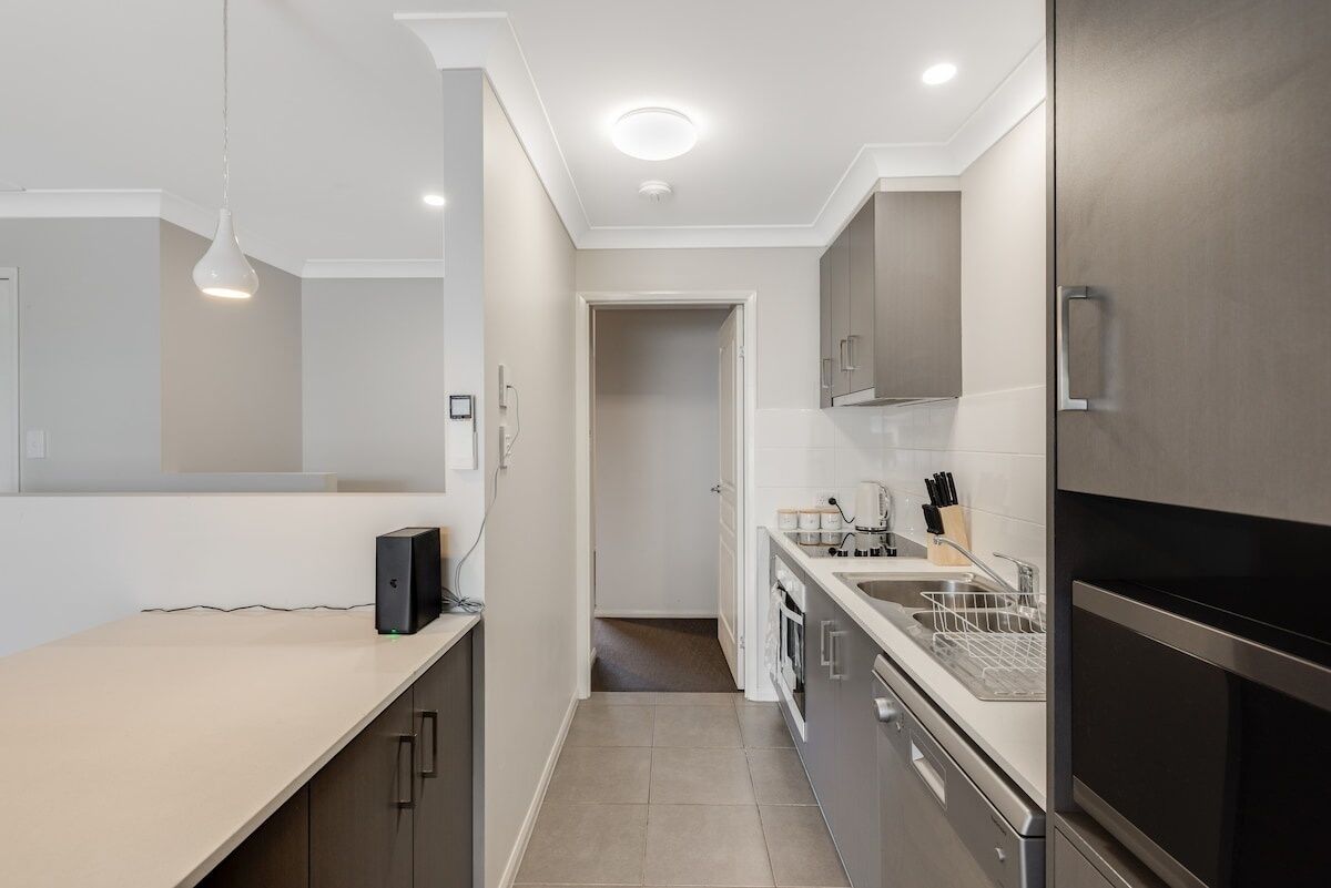 A modern kitchen with a countertop, sink, and stainless steel appliances.