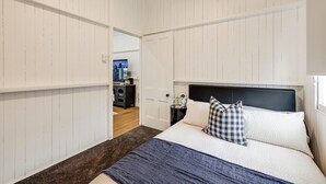 Un dormitorio con cama, mesita de noche y cómoda.