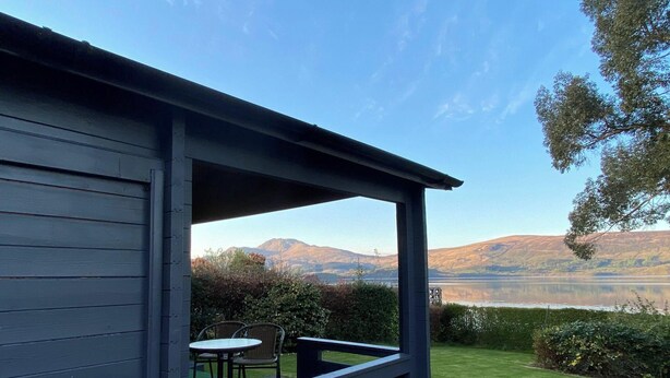 Un bâtiment moderne doté d’un balcon donnant sur un lac et des montagnes.