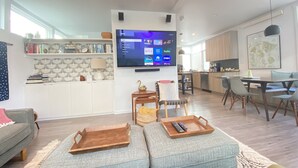Ein modernes Wohnzimmer mit Fernseher, Sofa und Couchtisch.