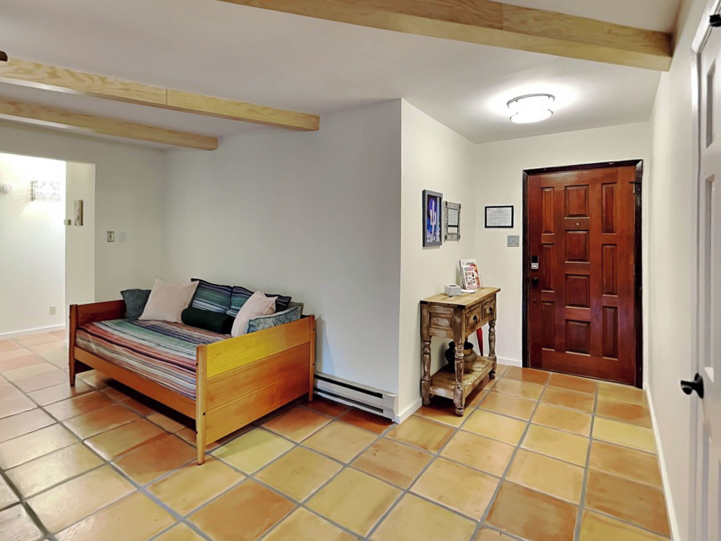 A bedroom with a bed, a wooden table, and a door.
