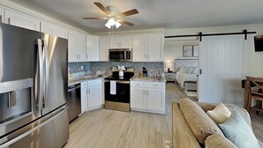 A modern kitchen with stainless steel appliances, white cabinetry, and a central island. - Lovers Key Beach Club by Distinctive Beach Rentals (Fort Myers Beach)