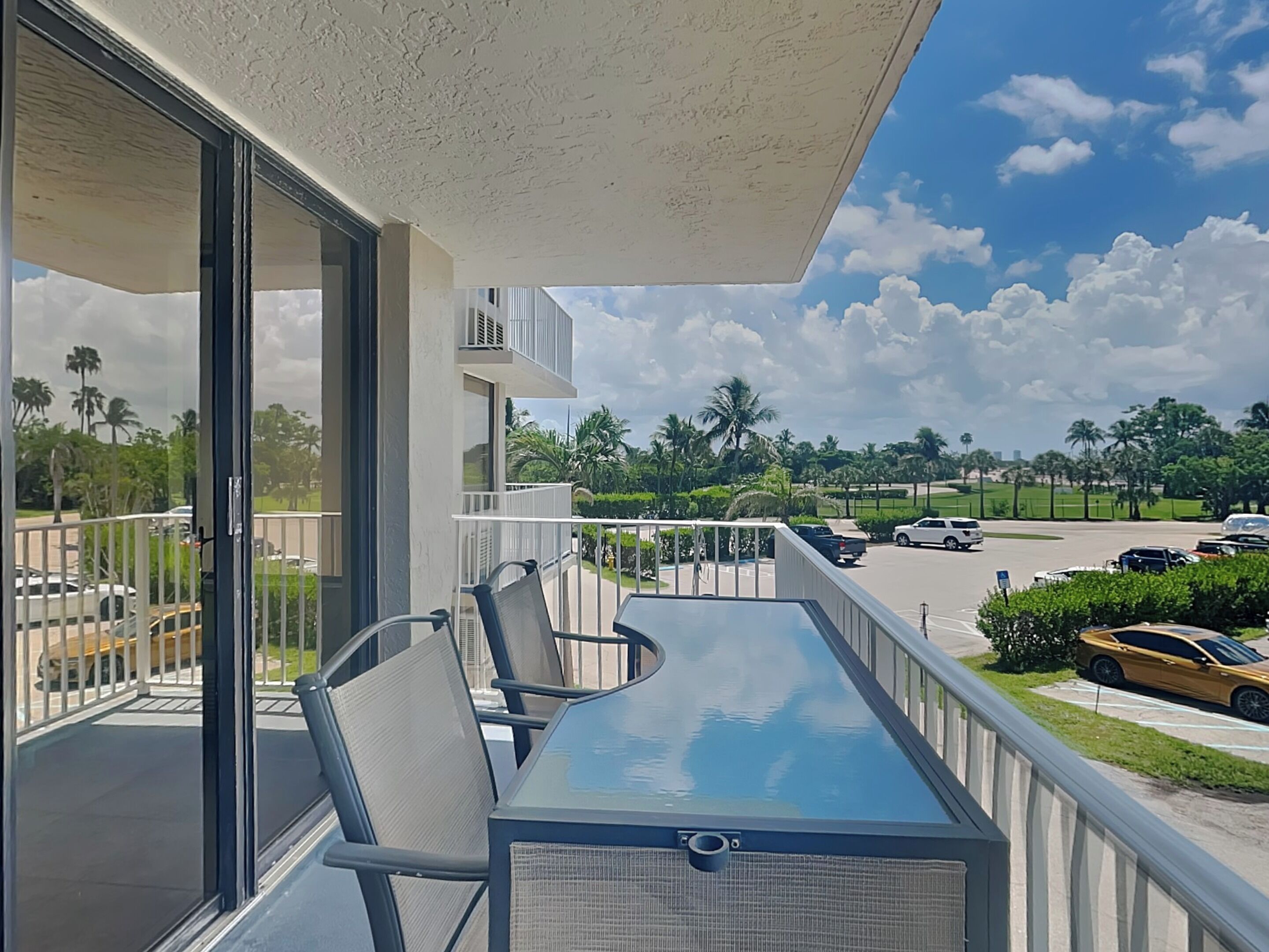 A balcony with a glass door, a table, and chairs.
