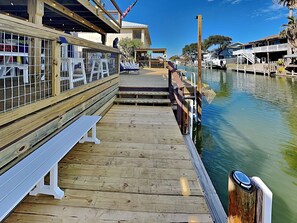 Enjoy waterfront seating with a view of the surrounding area from this pier, featuring benches and a table.
