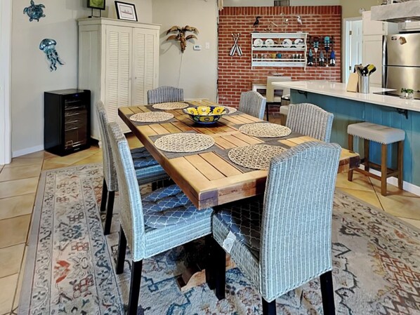 Un coin repas avec une table en bois, des chaises à revêtement bleu et un tapis à motifs.