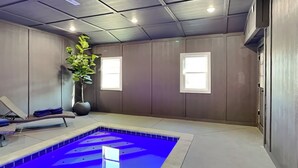 A spa room with a blue pool, a massage chair, and a large potted plant. - Swinging S'mores by Jackson Mountain Rentals (Sevierville)