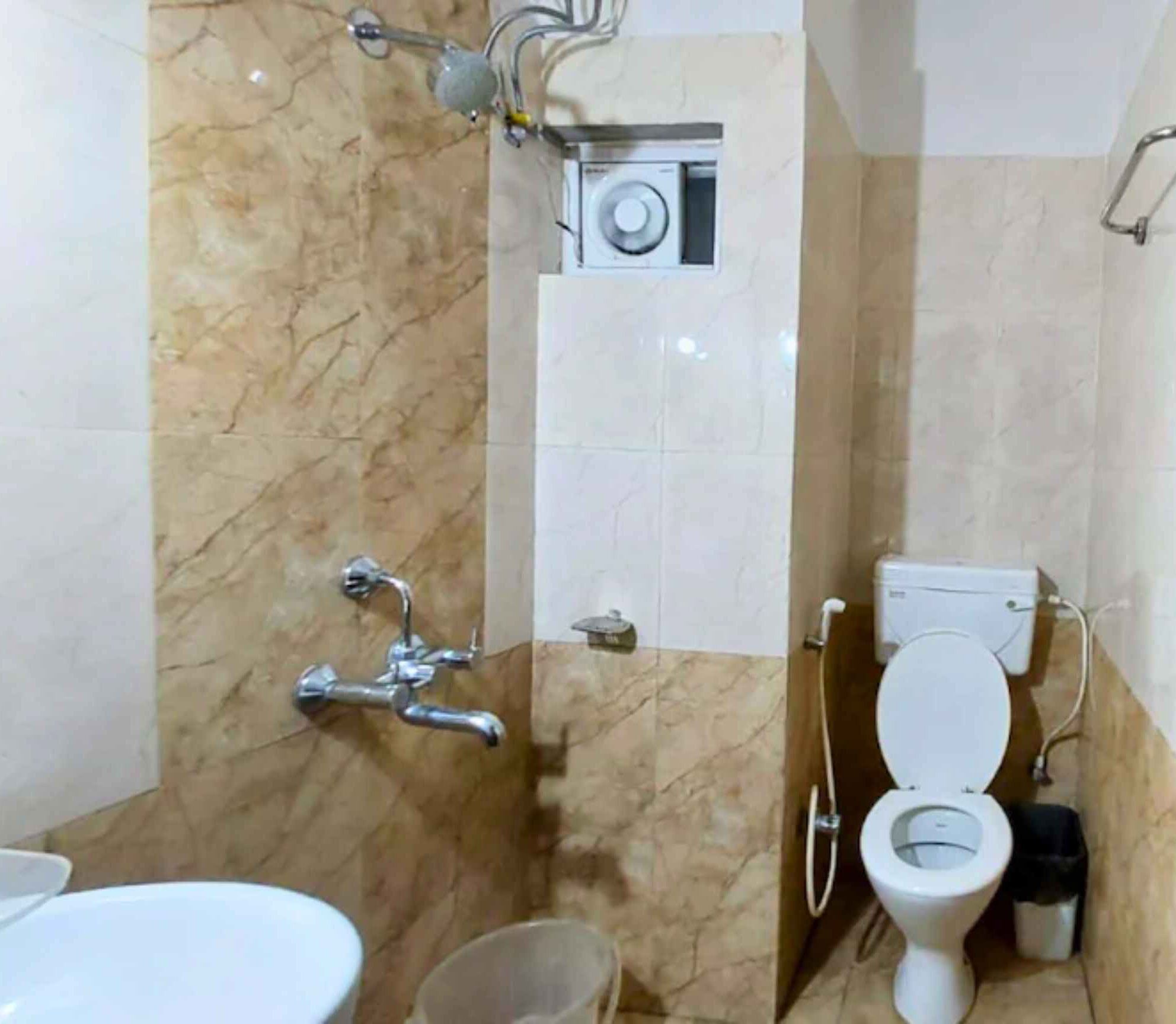 A compact bathroom with a toilet, bidet, and shower.