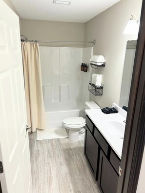 Een haardroger, handdoeken, zeep, toiletpapier