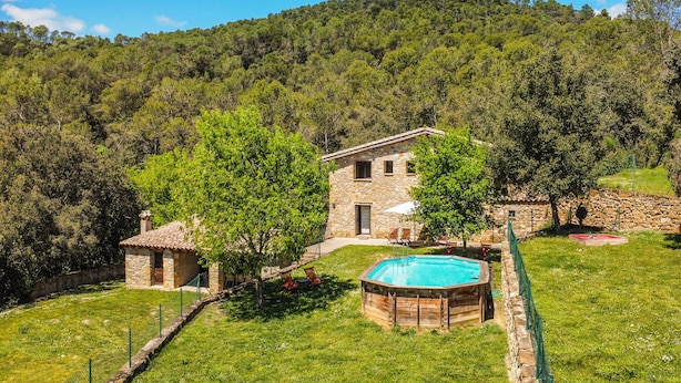 A stone house with a swimming pool surrounded by a stone wall and a grassy lawn. - Majordoms Molí - La Garrotxa (Beuda)