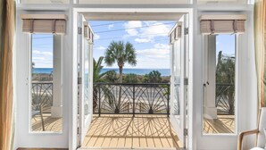 Un balcon avec vue sur l’océan et les palmiers.