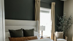 A neatly made bed with a white duvet, a brown leather pillow, and a beige throw blanket. - Backroads and Barrels Bourbon Trail Retreat (Salvisa)