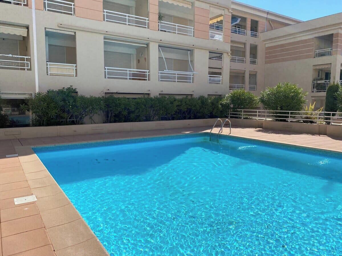 Une piscine rectangulaire à l’eau d’un bleu limpide, entourée d’une terrasse carrelée.