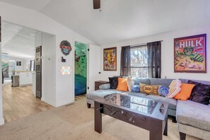 Ein Wohnzimmer mit Sofa, Couchtisch und Wandbildern.