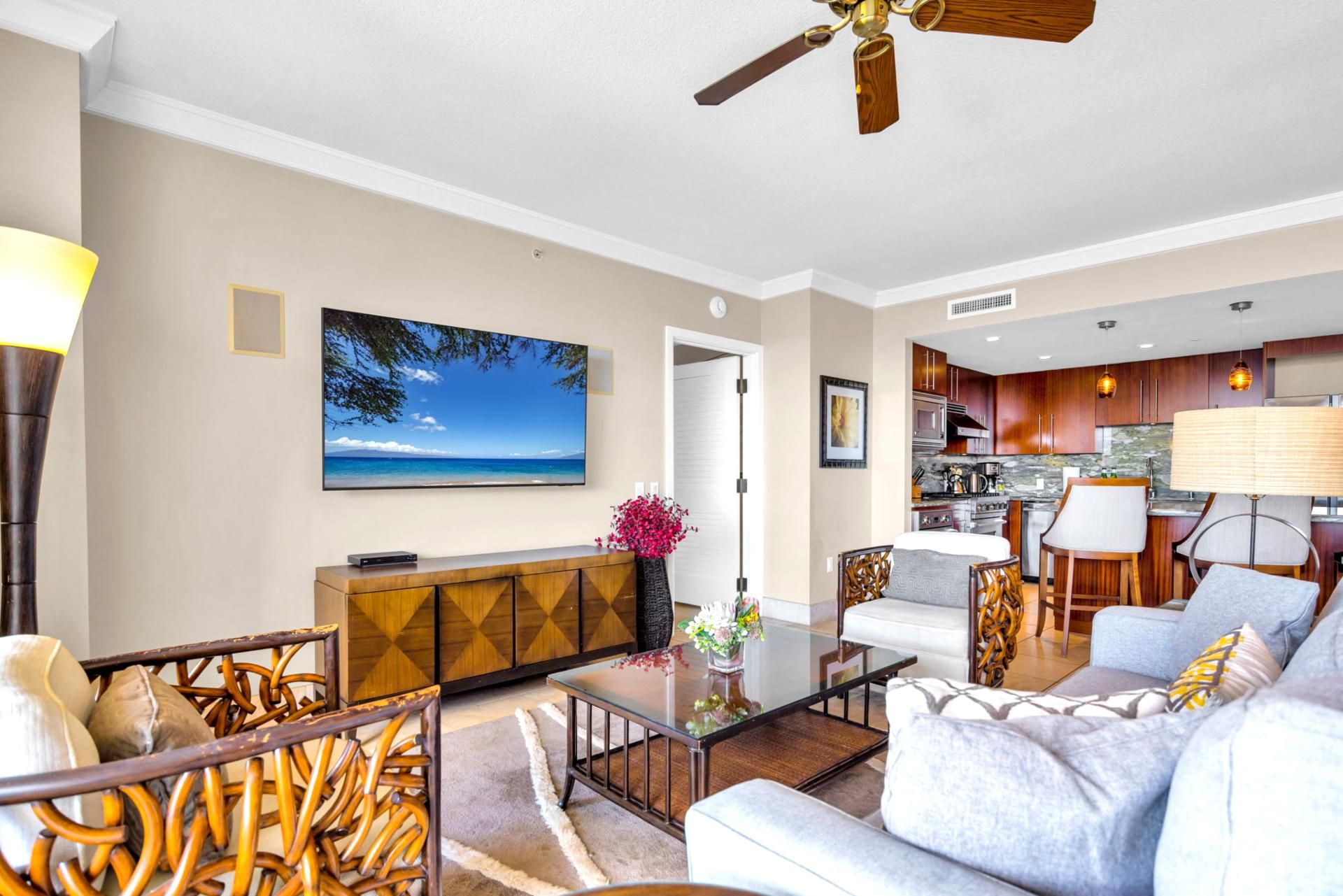 A living room with a TV, sofa, coffee table, and a dining area with chairs and a table.