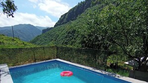 A rectangular swimming pool with clear blue water, surrounded by a black mesh fence. - Spacious 5-bedroom villa with swimming pool  WiFi and AC in lovely Alaverdi (Alaverdi)