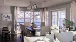 A dining area with a wooden table, chairs, and a hanging light fixture. - Cimmaron Bay Retreat (Sunrise Beach)