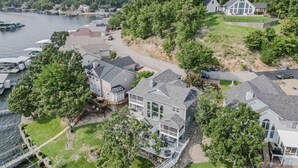 A large house with a spacious deck and a view of the water. - Cimmaron Bay Retreat (Sunrise Beach)