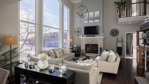 A spacious living room with a fireplace, large windows, and a television. - Cimmaron Bay Retreat (Sunrise Beach)