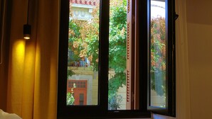 Une chambre d’hôtel avec un lit, une fenêtre avec des rideaux et un appareil de climatisation.