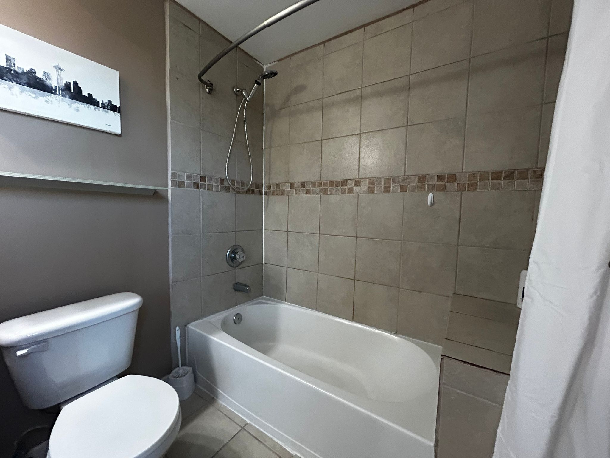 Une salle de bain équipée de toilettes, d’une baignoire et d’une douche.