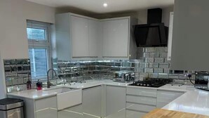 A modern kitchen with a central island, stainless steel appliances, and a large window.