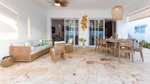A spacious living area with a sofa, chairs, a dining table, and a ceiling fan. - Villa Valentina Oceanfront Bliss (Sosúa)