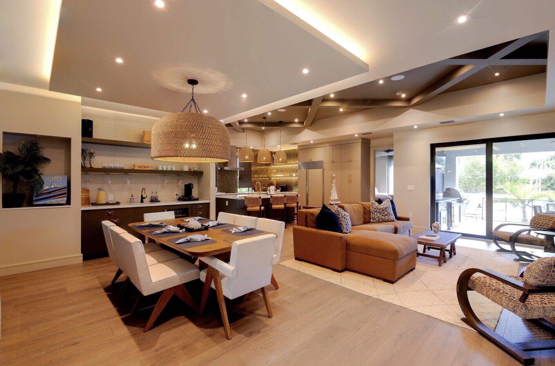 A spacious living area with a dining table, sofas, and a kitchen in the background.
