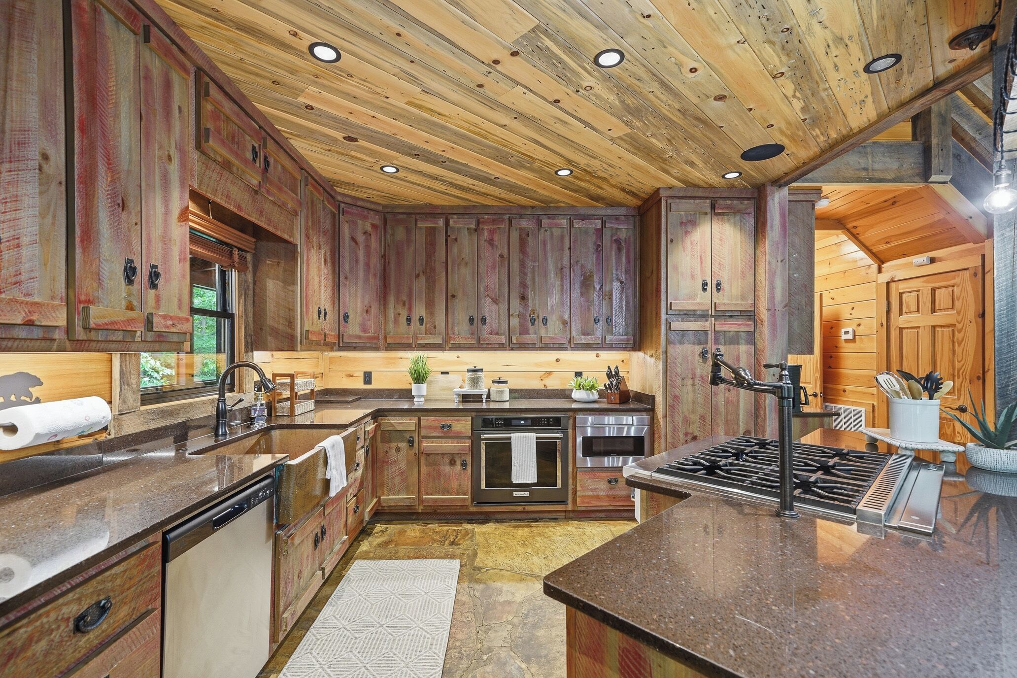 A kitchen with wooden cabinets, a stove, and a sink.