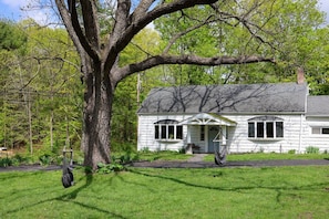 A white house with a porch, a swing hanging from a tree, and a grassy yard. - Cottage w/ hot tub 15min to Windham & Catskill (Acra)