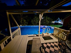 A covered deck with a pool, outdoor furniture, and a view of a house in the background. - Cottage w/ hot tub 15min to Windham & Catskill (Acra)