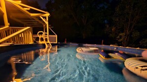 En swimmingpool med klart vand, en træterrasse og oppustelige ringe.