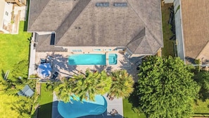 An aerial view of a house with a swimming pool, a covered patio, and a well-maintained lawn. - Sleeps 18! Pool, Hottub, Game Room, Blocks to Beach Vilano Villa by Avantstay (St. Augustine)