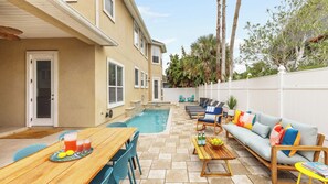 A backyard with a pool, outdoor seating, and a dining area. - Sleeps 18! Pool, Hottub, Game Room, Blocks to Beach Vilano Villa by Avantstay (St. Augustine)