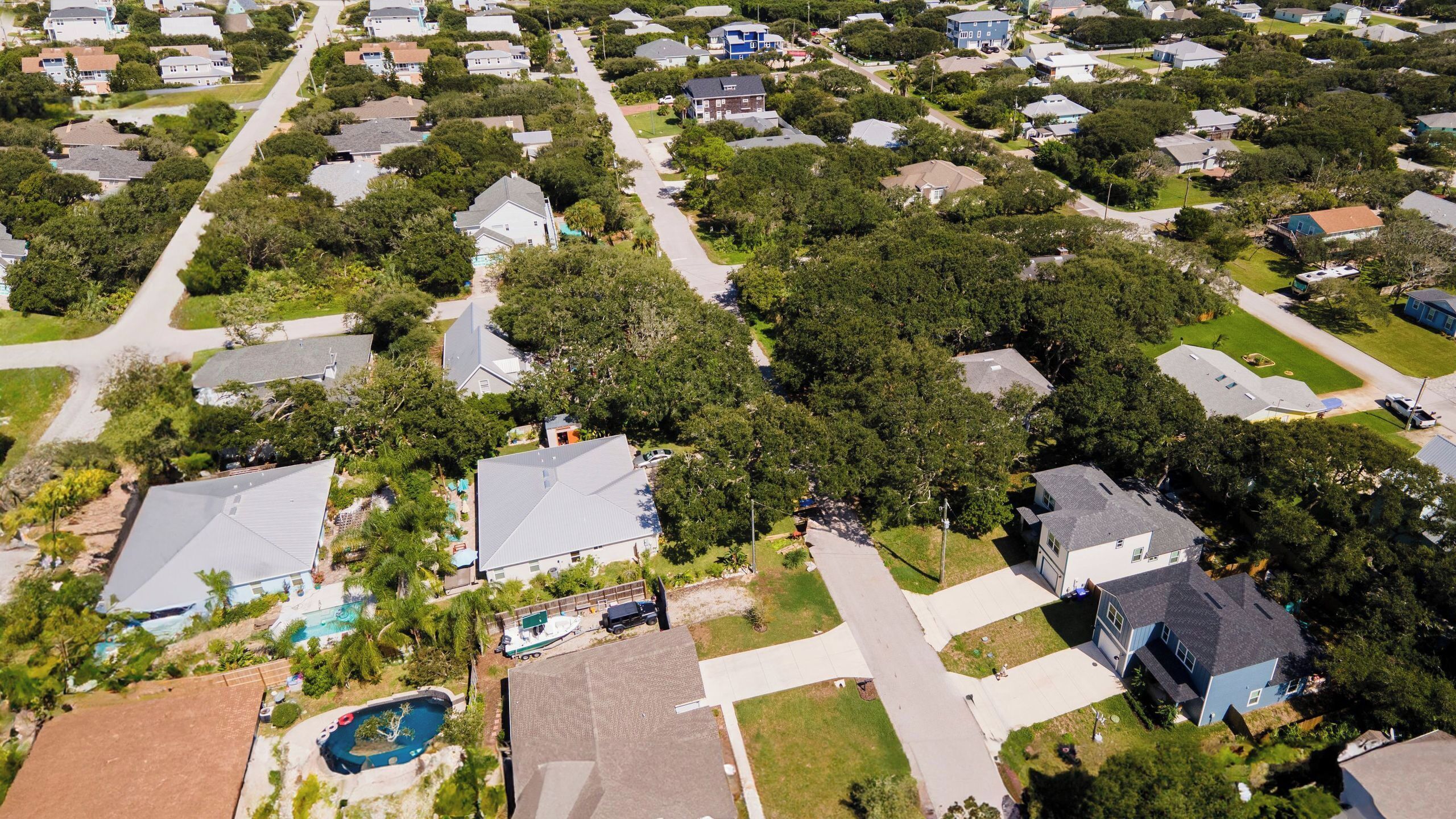 Vista aérea de uma área residencial com casas, ruas e uma piscina.