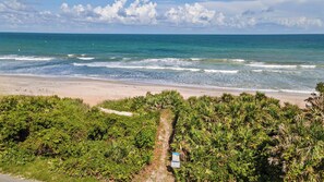 A beach with a path leading to the water, surrounded by dense vegetation. - Beach Retreat w/ Putting Green, Hot Tub, 2 Free Bikes Golden Hour by Avantstay (St. Augustine)