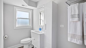 A modern bathroom with a toilet, sink, and towel rack. - Modern Renovated Suite in Riverside  (Riverside)