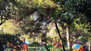 A playground with various play structures including slides, swings, and climbing areas. - Golden Seaview Apartment  (Sarande)