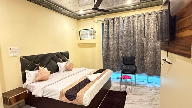 Ein Schlafzimmer mit Bett, Stuhl, Vorhang und Deckenventilator.
