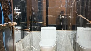 Ein Badezimmer mit Toilette, Duschbereich und Waschbecken.